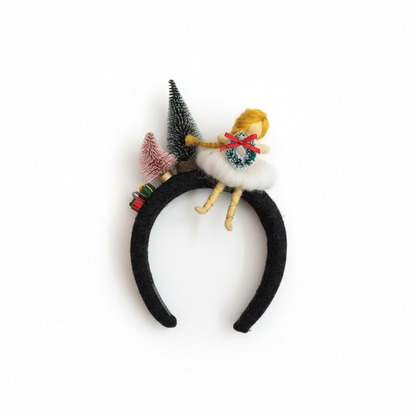Black headband with decorative elements including a small figurine and trees on a white background