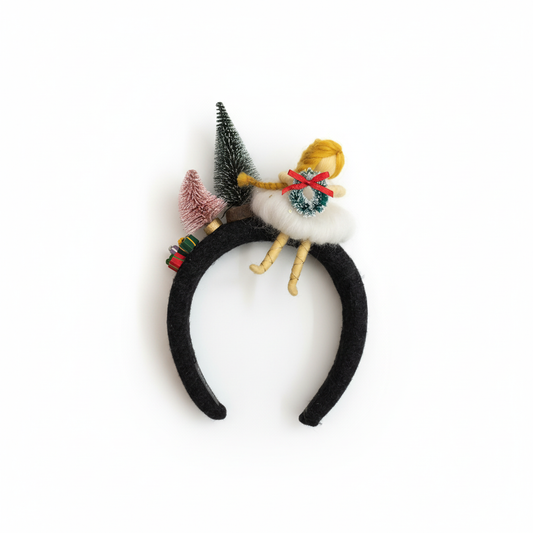 Black headband with decorative elements including a small figurine and trees on a white background