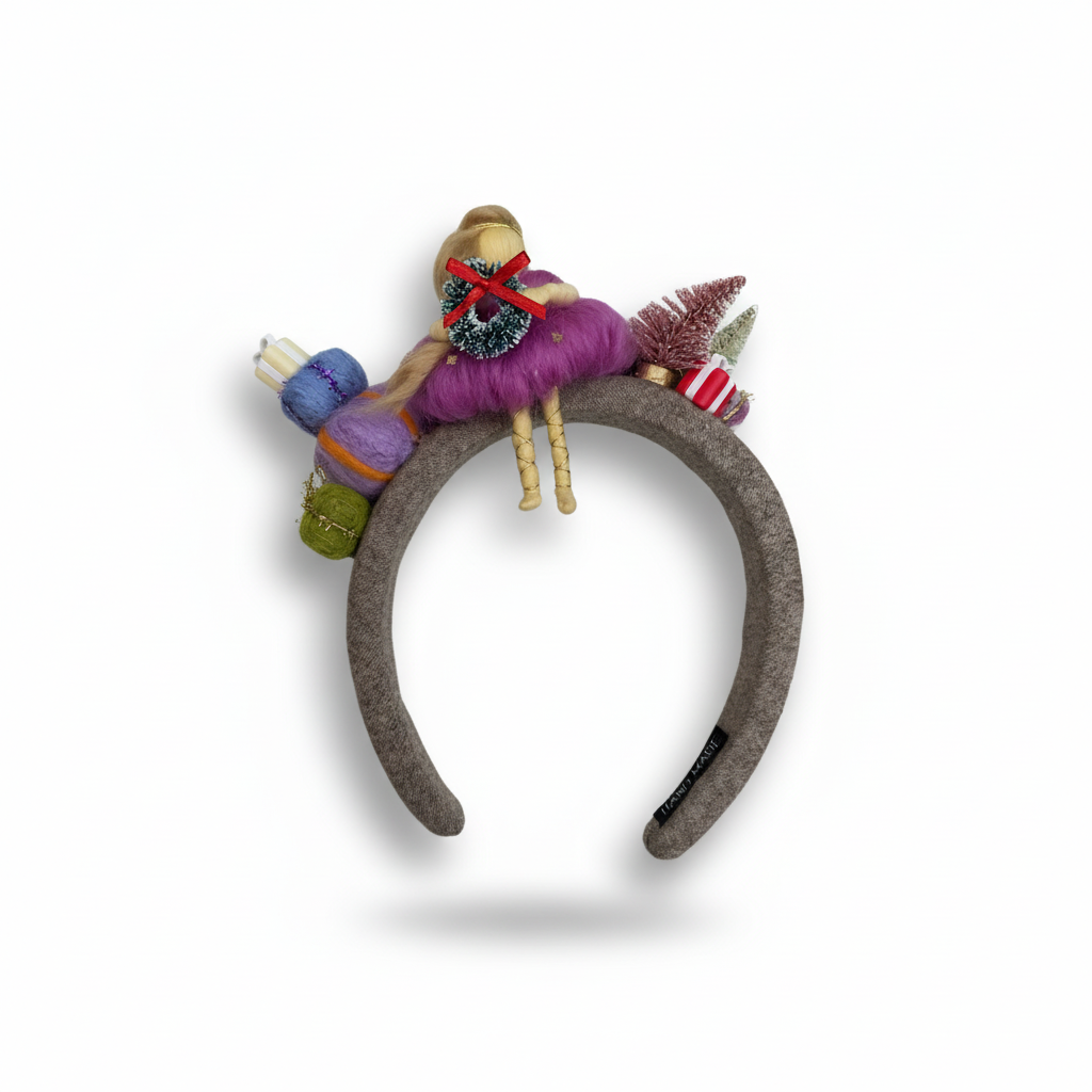 Decorative headband with colorful yarn and small figurines on a white background