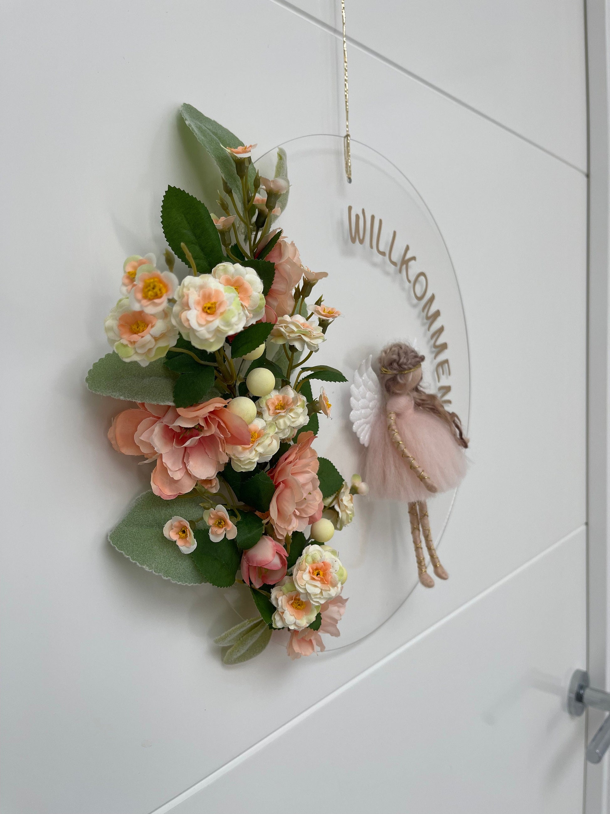 Decorative wreath with flowers and fairy on a white door