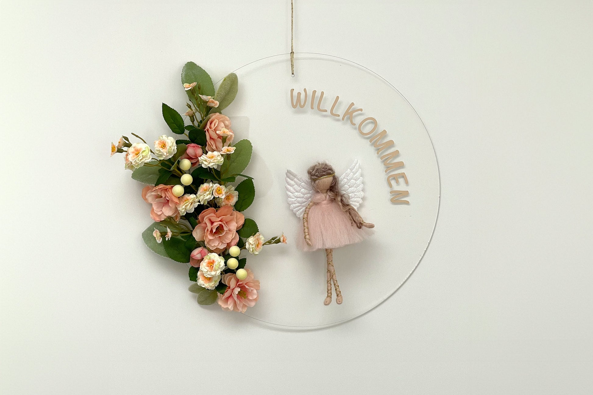 Decorative wall hanging with flowers, fairy figure, and 'WILLKOMMEN' text on a white background